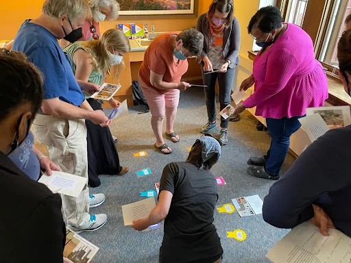 Flores, T. (2022). Teachers at the Schoodic Institute finding their partners by matching the project description to the illustrated title. (Photograph)