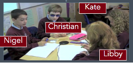 Children (Nigel, Christian, Kate, Libby) sitting at a table with workbooks